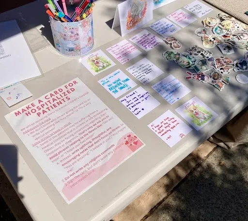 A sign reading 'Make a card for hospitalized patients' beside the finished cards