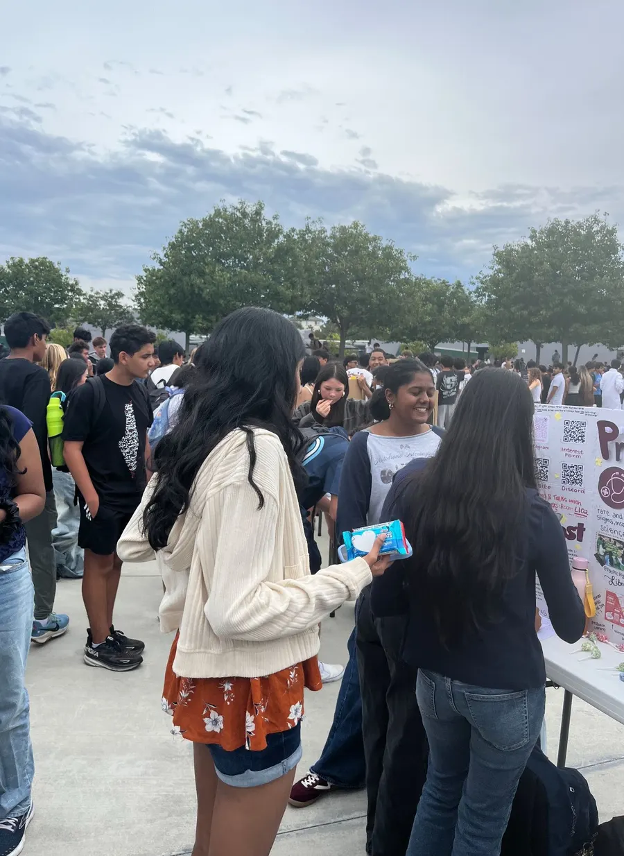 Members talking with an interested student at the Club Rush booth