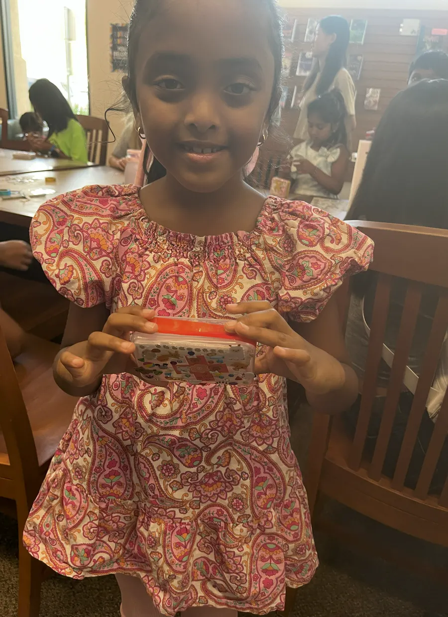 A student holds up the first aid kit she decorated