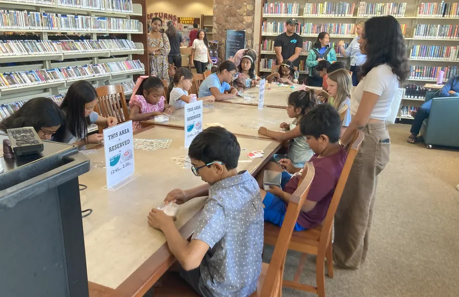 Volunteers helping students fill their kits at the tables