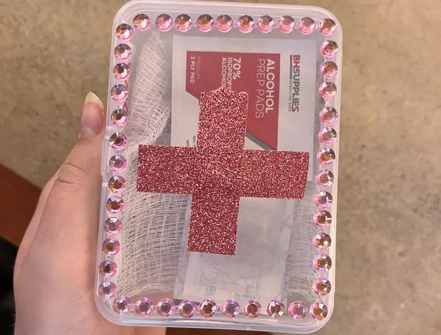 A finished first aid kit decorated with a red cross and gems