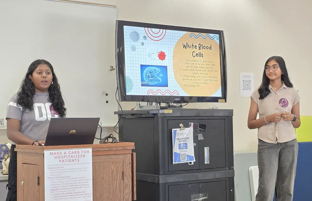Two volunteers present a slide about white blood cells
