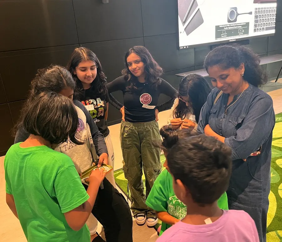 Volunteers explain the rules of the immune system game to the children