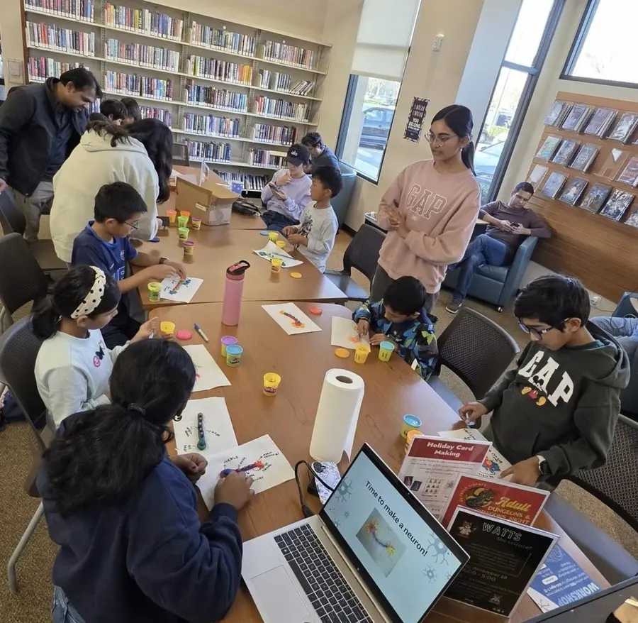 Volunteers and children building neuron models with clay