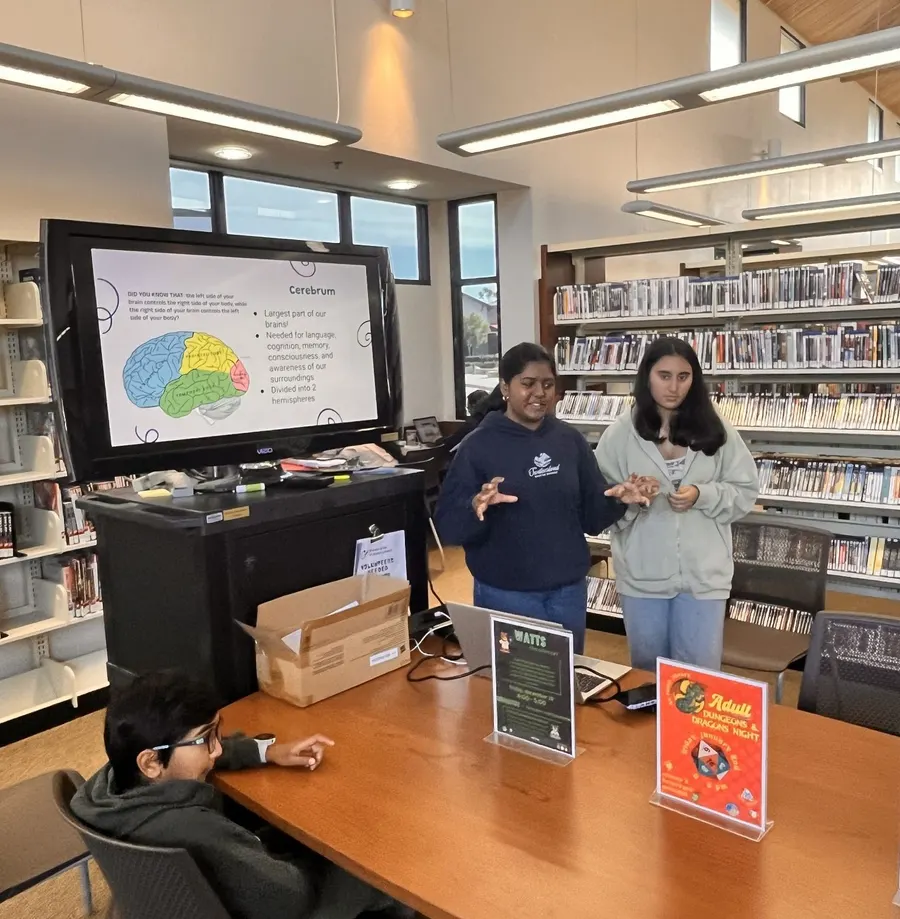 Two volunteers present a slide about the parts of the brain