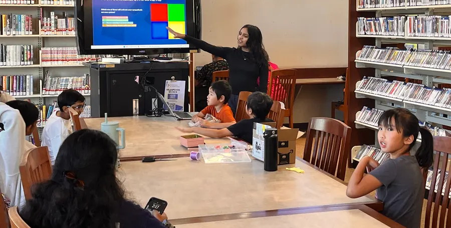A volunteer explains a slide about how stress affects the body