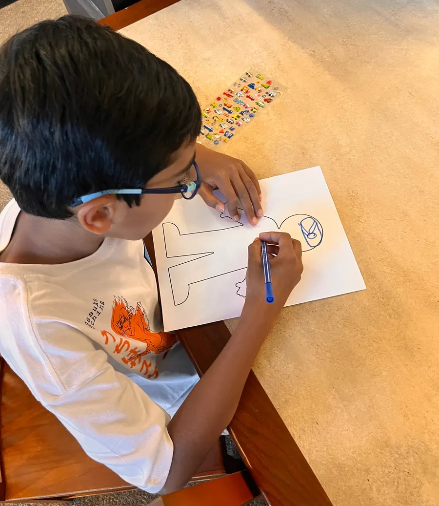 A student draws on his paper body outline