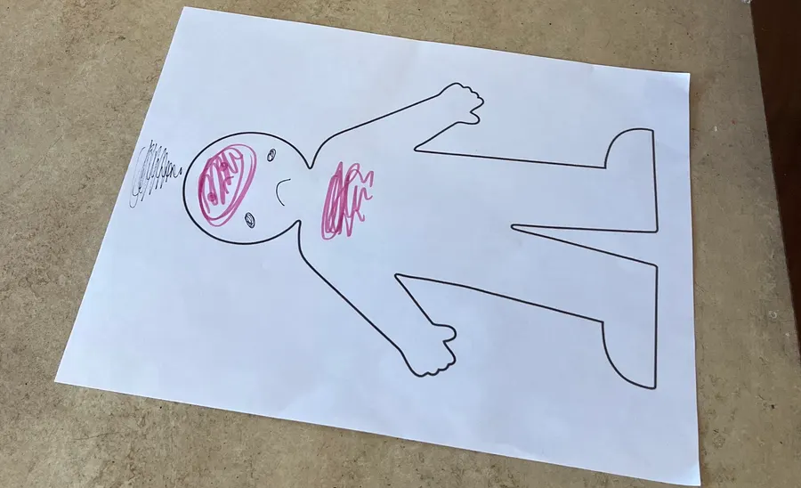A paper body outline colored in to show where a child feels stress
