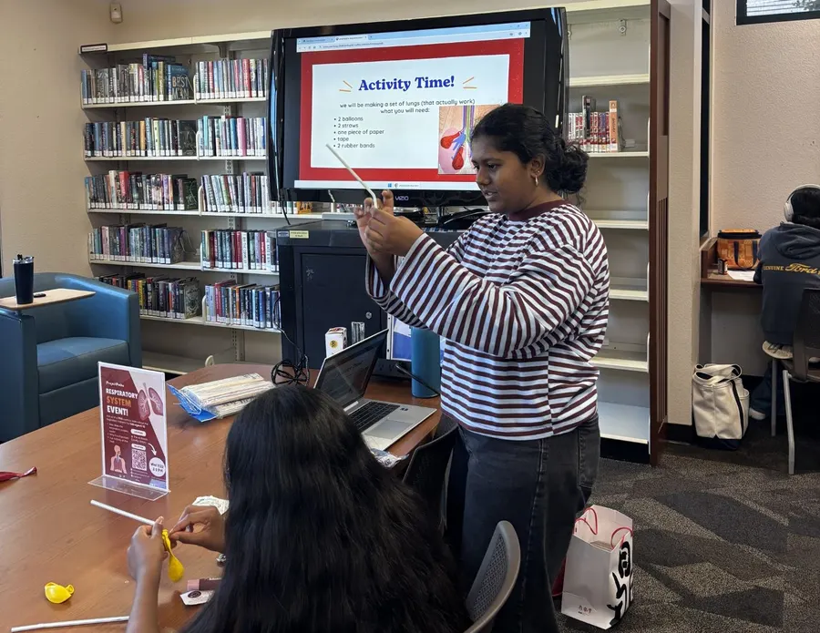 A volunteer points to an 'Activity Time!' slide on the screen