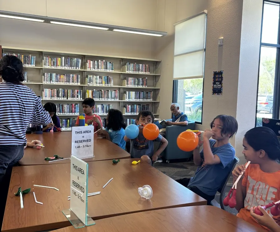 Children at the library table with orange balloons ready for the lung activity