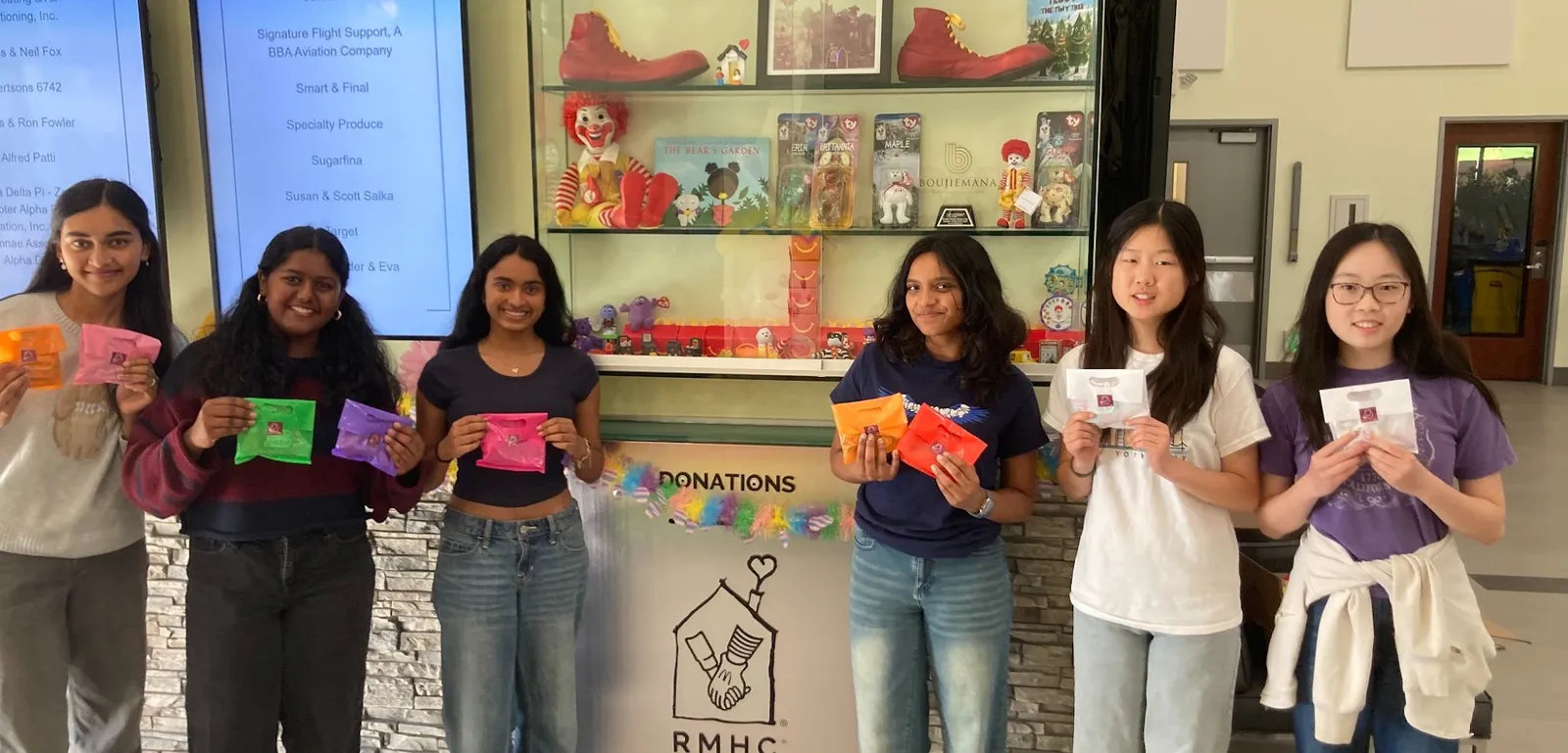 Six ProjectPatho members holding the treats and care package items they donated to Ronald McDonald House Charities